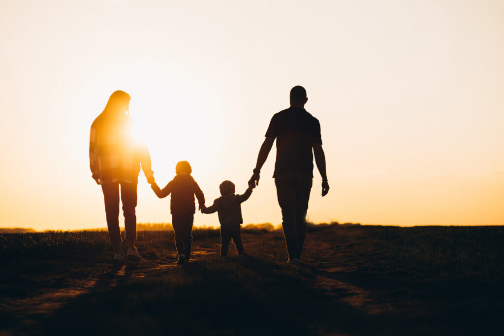 A family holding hands in the sun light on the south downs